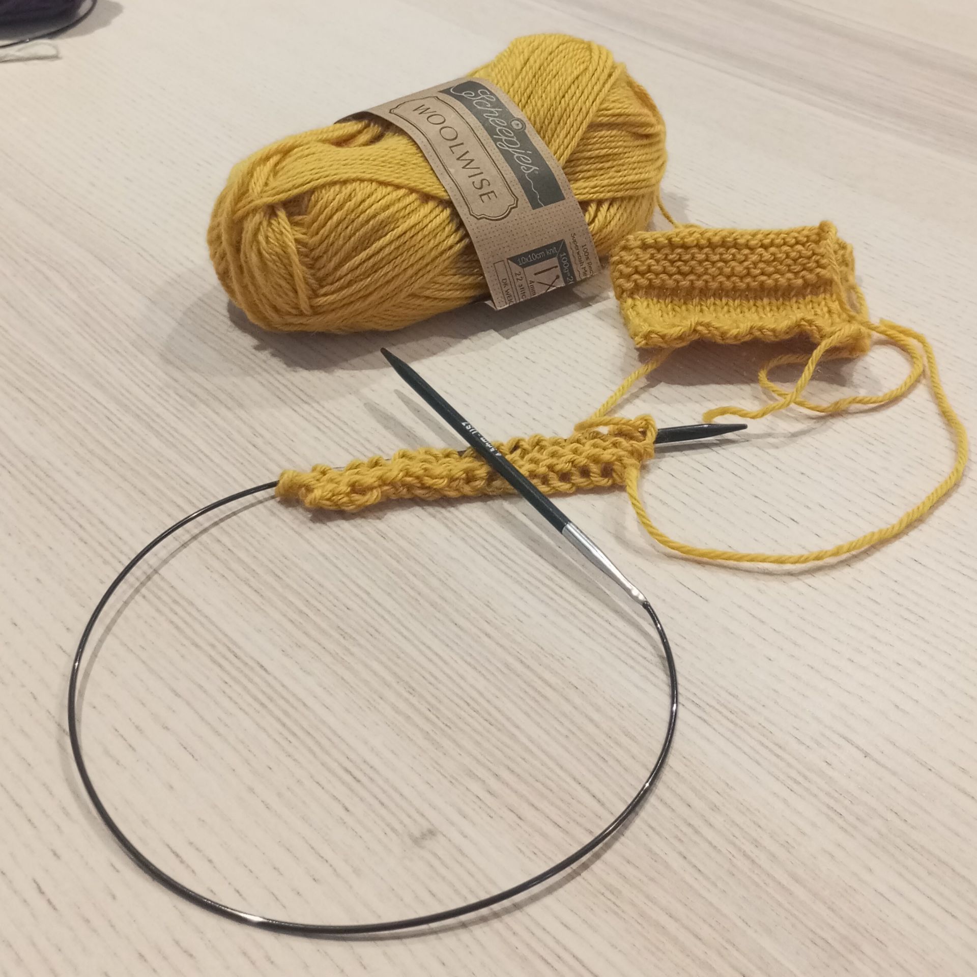 début d'un projet en tricot jaune avec une pelote et un exemple